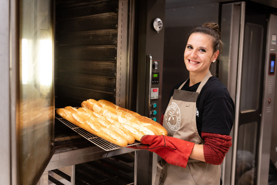 boulangere sortant son pain du four avec un grand sourire - Reportage Photo - Super Intermarché - Reichshoffen